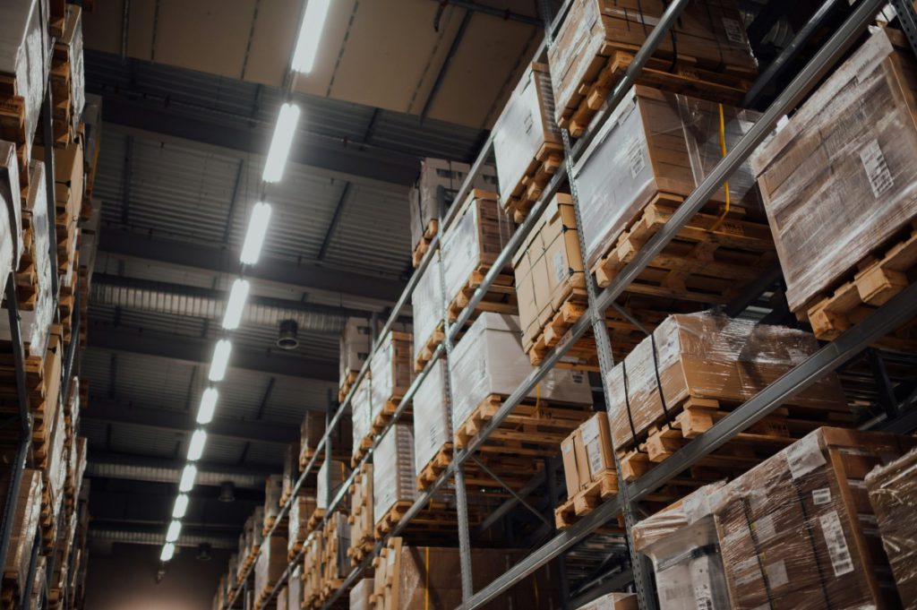 A metal rack full of plastic-wrapped cardboard boxes in a warehouse